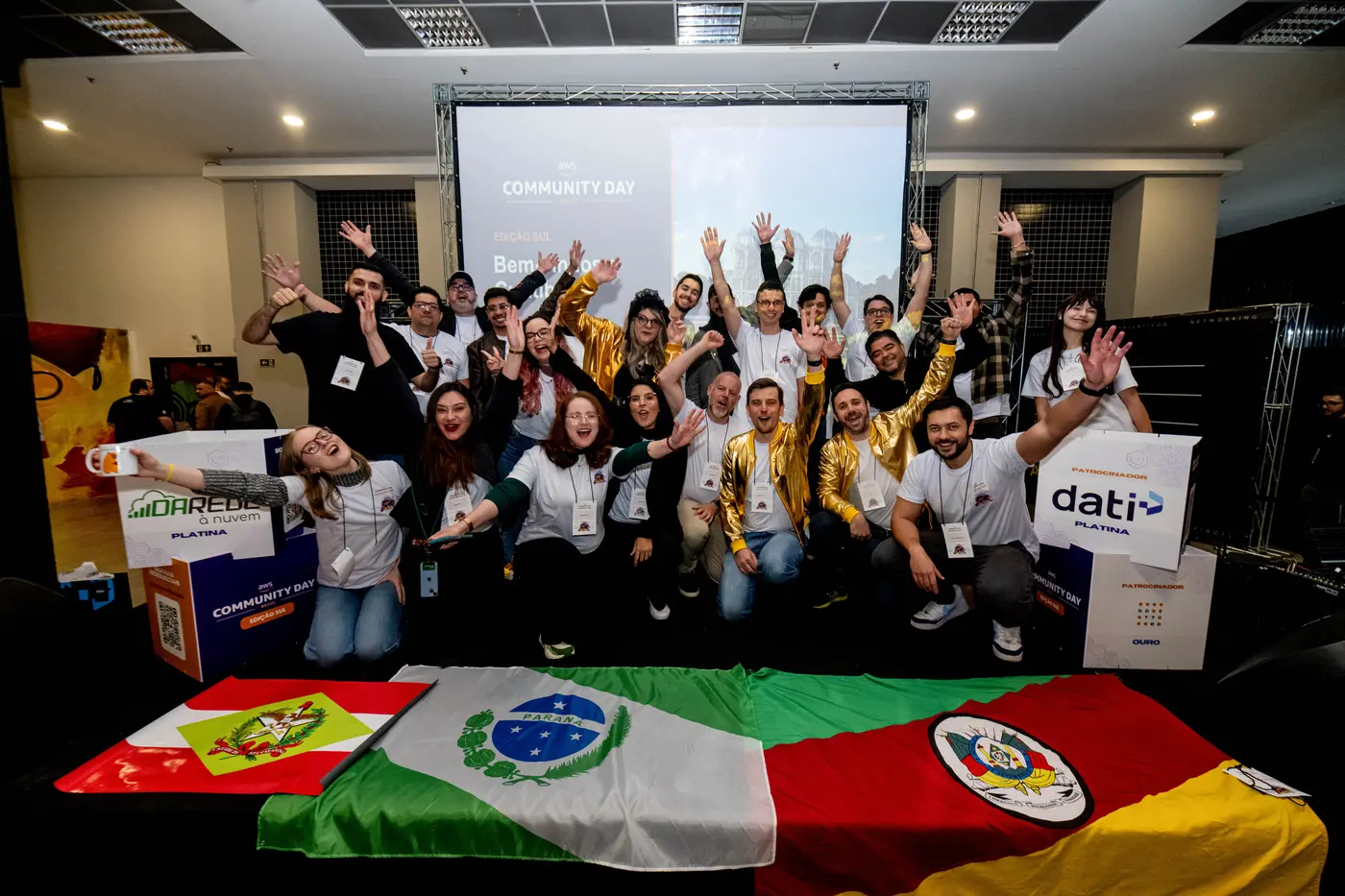 Organização e voluntários do AWS Community Day Sul com as bandeiras do Paraná, de Santa Catarina e do Rio Grande do Sul