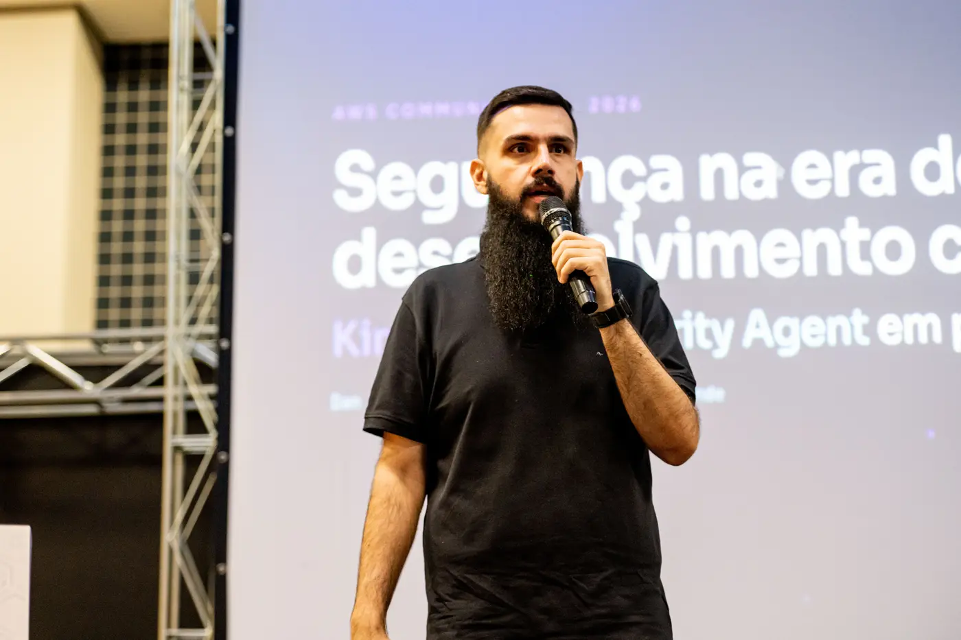 Dan Rezende no palco do AWS Community Day Sul com o slide de título da palestra